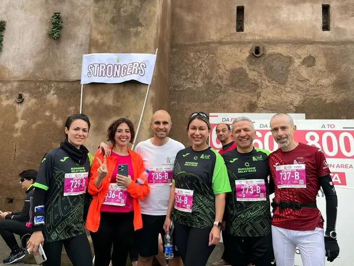 Staffettisti Strongers con i pettorali della staffetta sotto la bandiera Strongers