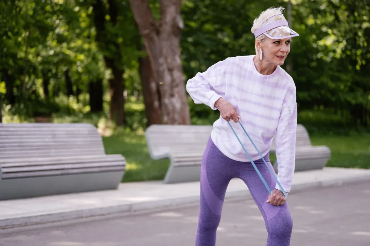 Donna over 50 durante un allenamento fisico strutturato, concentrata e in forma