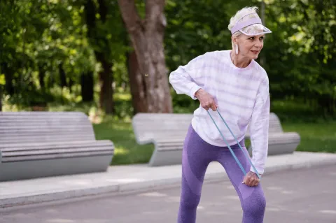 Donna over 50 durante un allenamento fisico strutturato, concentrata e in forma