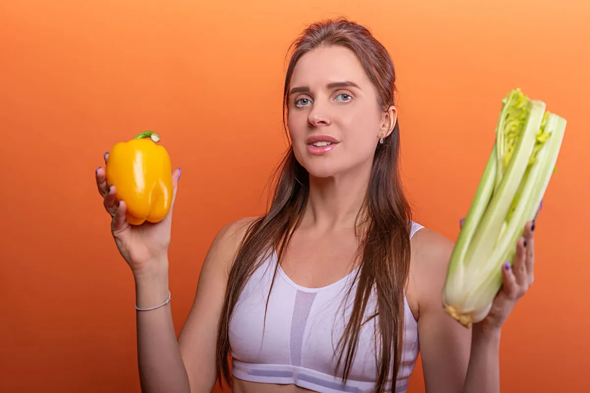 Atleta che mangia un pasto plant-based ricco di verdure fresche, pronto ad allenarsi per la ricerca oncologica.