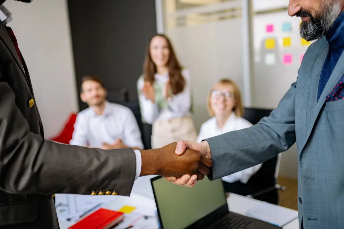 Professionisti stringono la mano in segno di partnership aziendale per sostenere la ricerca oncologica