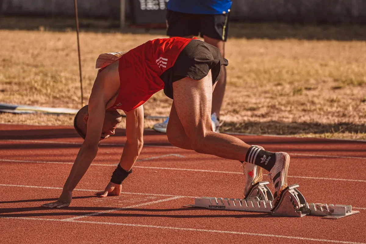 Atleta che si prepara al via di una gara, concentrato e in forma, pronto per la competizione