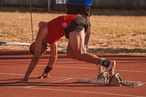 Atleta che si prepara al via di una gara, concentrato e in forma, pronto per la competizione