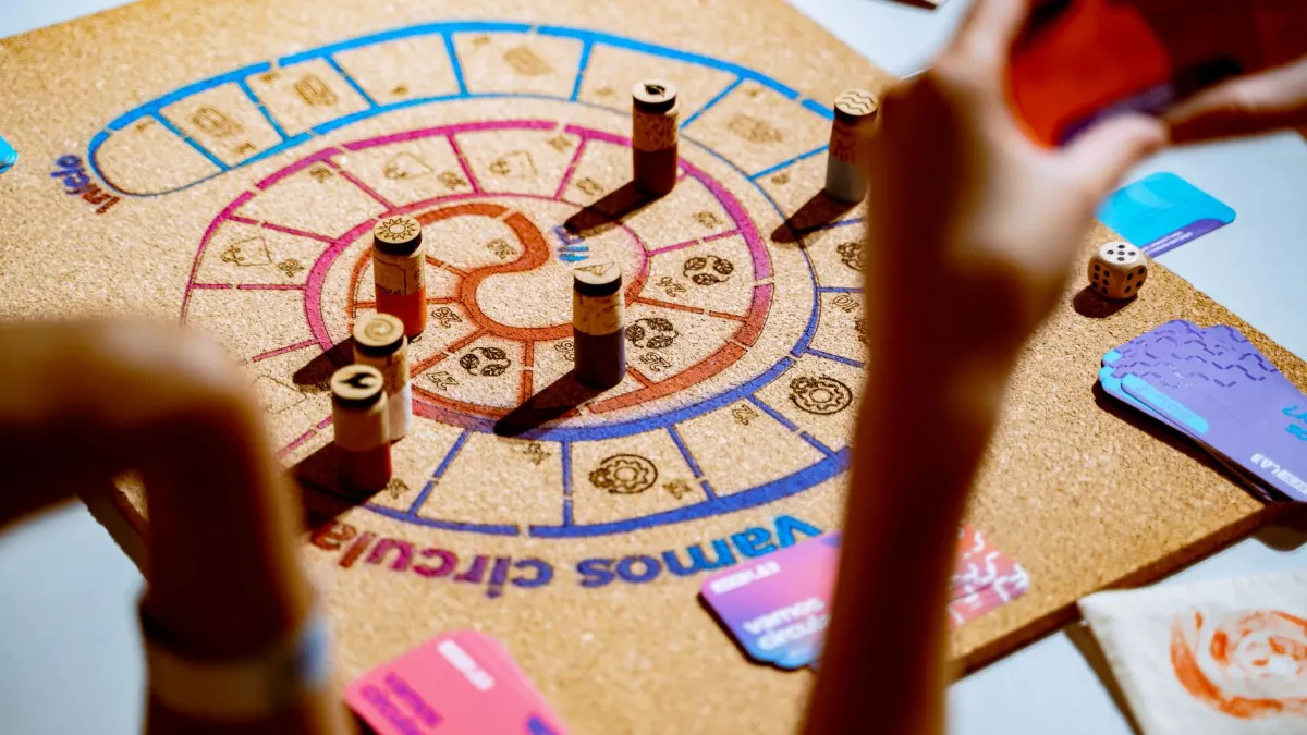 Una famiglia riunita attorno a un tavolo gioca a un gioco da tavolo educativo insieme